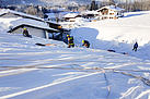 Sporthalle mit Hilfe von Planen vom Schnee befreien